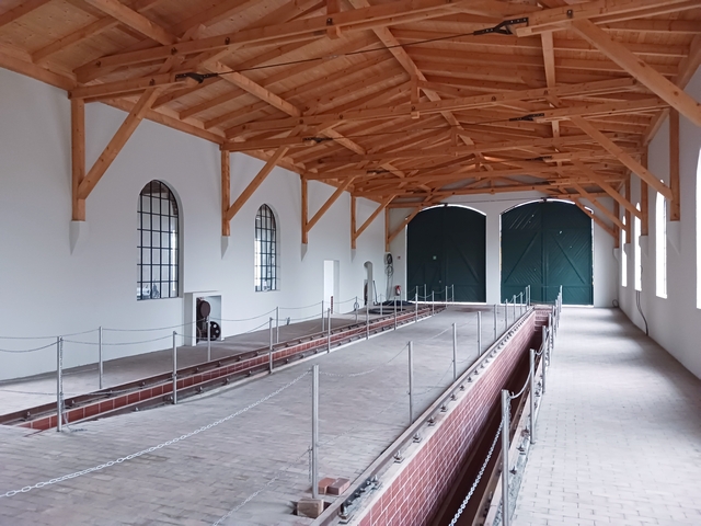 Abb.: Die Abstellhalle wird von der aufwendig rekonstruierten Dachkonstruktion dominiert. Untersuchungrube, Gleise und Bodenbelag sind inzwischen fertiggestellt. Die Gruben sind jetzt auch durch Absperrketten gesichert, so dass man gefahrlos Gäste mit in die Halle nehmen kann.