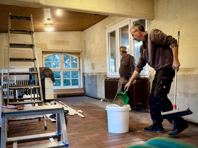 Abb.: Die Lösung: Alles muss raus! Was im letzten Jahr mit neuen Fenstern begann, wird nun fortgesetzt: die Renovierung des Aufenthaltsraumes. Alle Möbel raus, die Wände frei räumen und zum Schluss kam auch noch die Holzverkleidung der Decke runter. Ralf und Kai staunen über die Größe des leeren Raumes. Sonst geht es hier eher eng zu.